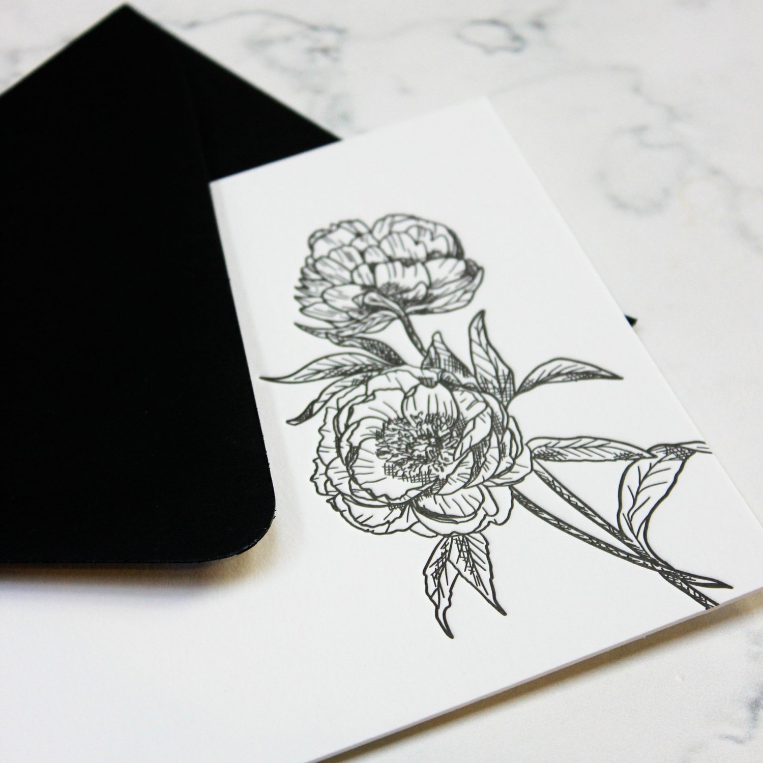 Letterpress floral card with black envelope on marble