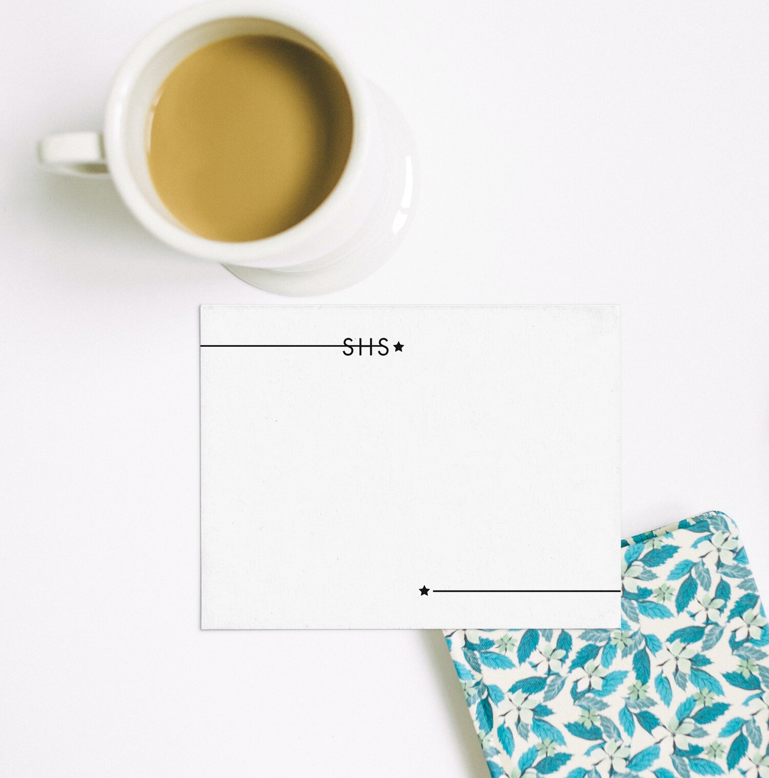 Monogrammed letterpress note card on a styled desk